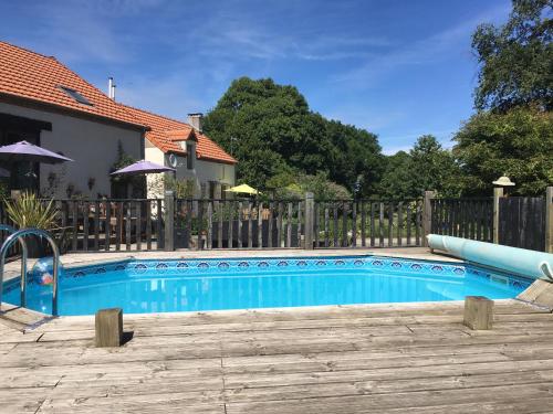 a blue swimming pool in a yard with a fence at Ancient Oaks Centre Val-De Loire-Culan in Saint-Saturnin