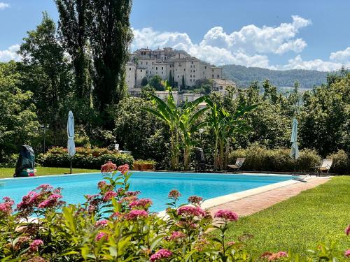 una piscina con un grande edificio sullo sfondo di Borgo San Valentino ad Arrone