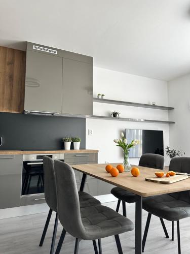 a kitchen with a wooden table and chairs at Rivapark in Dunajská Streda