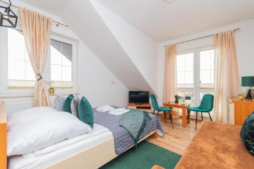 a bedroom with a bed and a desk and chairs at Monika II in Krynica Morska