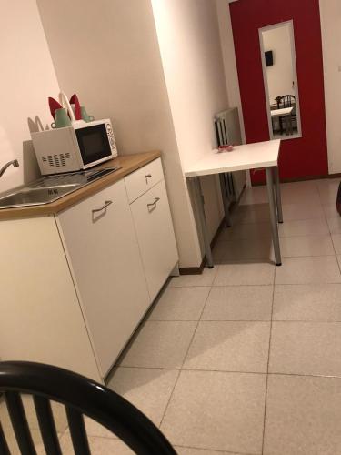 a kitchen with a table and a microwave on a counter at B&B Le Magnolie in Amorosi