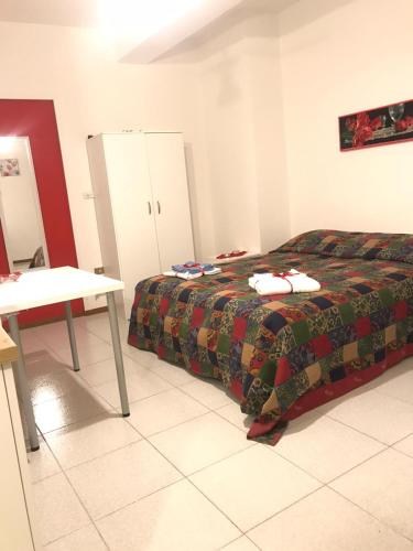 a bedroom with a bed and a table and cabinets at B&B Le Magnolie in Amorosi