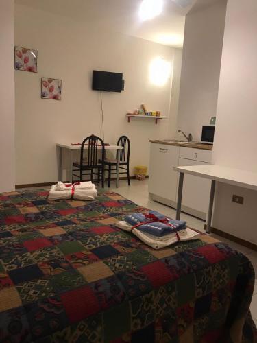 a room with a bed and a kitchen with a table at B&B Le Magnolie in Amorosi