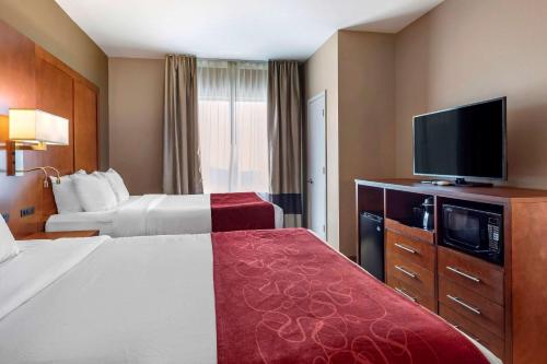 a hotel room with two beds and a flat screen tv at Comfort Suites Florence Shoals Area in Florence