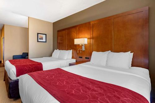 a hotel room with two beds with red sheets at Comfort Suites Florence Shoals Area in Florence