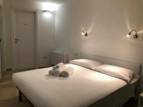 ein Schlafzimmer mit einem weißen Bett mit zwei Handtüchern darauf in der Unterkunft Casa Vacanze Zeffiro vista mare con giardino in Àrbatax