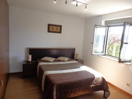 1 dormitorio con cama y ventana en Casa da Lagoa, en Alvarães