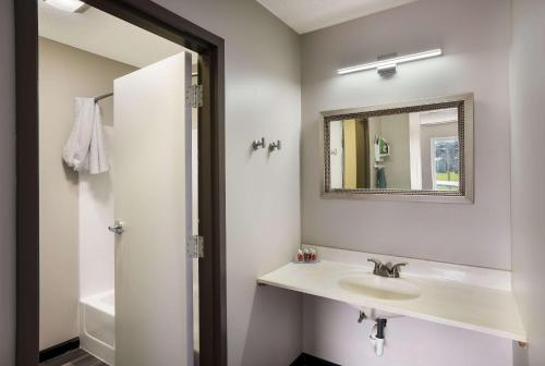 a bathroom with a sink and a mirror at Econo Lodge Inn & Suites in Canandaigua