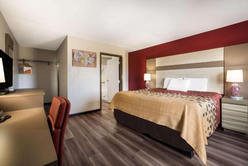 a hotel room with a bed and a television at Econo Lodge Inn & Suites in Canandaigua