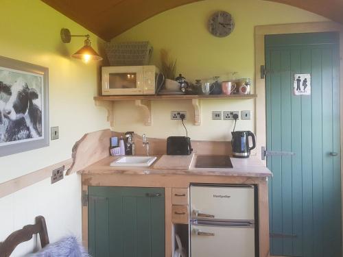uma cozinha com uma porta verde e uma bancada em Fell Foot - Ukc5294 em Bassenthwaite