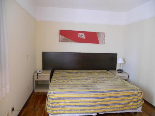 una camera con un letto con una coperta a righe di Imperial Suzano Shopping Hotel a Suzano