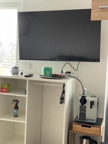 a large screen on top of a white table at Studio T à 5mn euro airport avec terrasse in Saint-Louis