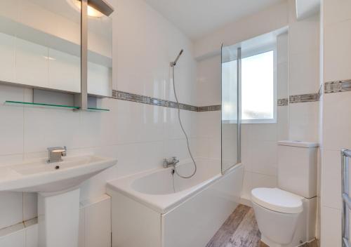a white bathroom with a sink and a toilet at St Margarets Flat in Rottingdean