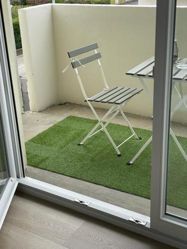 a chair sitting on a balcony with a table at Studio T à 5mn euro airport avec terrasse in Saint-Louis