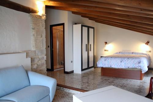 een slaapkamer met een bed en een bank in een kamer bij Casa de San Lorenzo in Úbeda