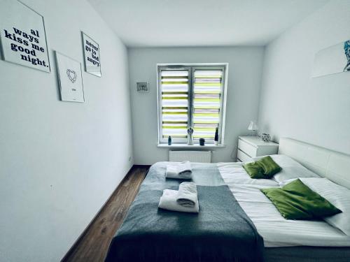 a bedroom with a large bed with towels on it at AL-Dom Apartamenty Apartament Anioł in Kołobrzeg