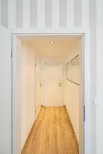 an empty hallway with white walls and wood floors at Hotel Busche am Dom in Münster
