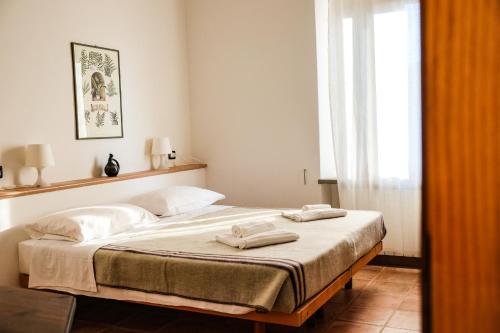 1 dormitorio con 1 cama con 2 toallas en Agriturismo biologico Bulichella, en Suvereto