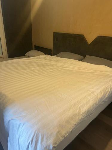 ein Bett mit weißer Bettwäsche und Kissen darauf in der Unterkunft Résidence bord de Loire euro 6 in Decize