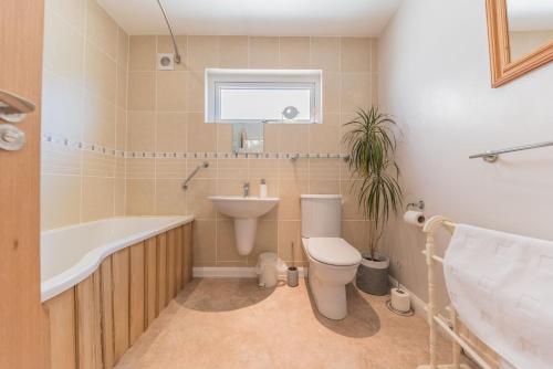 a bathroom with a toilet and a sink and a bath tub at Hazel Cottage Coniston in Coniston