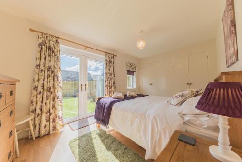 a bedroom with a bed and a large window at Hazel Cottage Coniston in Coniston