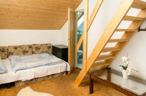 a bedroom with a bed and a stair case at Chata u Tata in Mlynky 