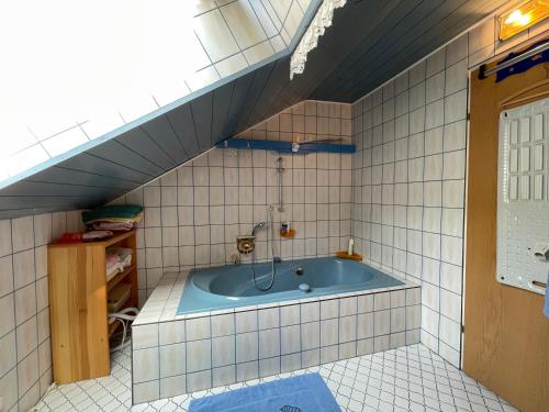 ein Bad mit einer Badewanne in einem gefliesten Zimmer in der Unterkunft Einhornhaus in Schottwien