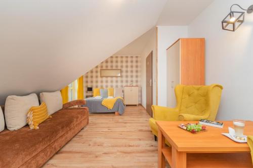a living room with a couch and a bed at Monika II in Krynica Morska