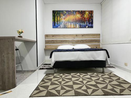 Un dormitorio con una cama y un cuadro en la pared. en Fort House, en Cali