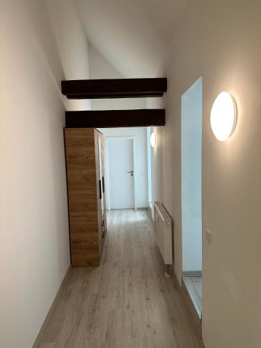 an empty room with a hallway with a door and a wooden floor at Dachterrassenwohnung Katharinenschule in Eisenach