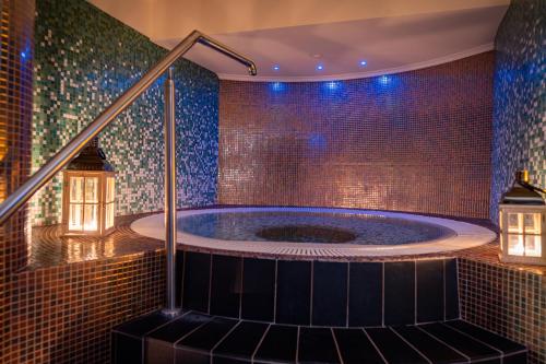 a jacuzzi tub in a room with mosaic tiles at HAVET Hotel Resort & Spa in Dźwirzyno