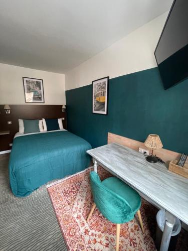 una camera d'albergo con letto, tavolo e scrivania di The Originals Boutique, Hôtel d'Angleterre, Le Havre, centre, plage a Le Havre