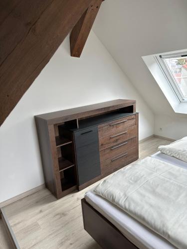 a bedroom with a bed and a wooden dresser at Dachterrassenwohnung Katharinenschule in Eisenach