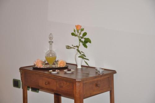 a wooden table with a vase and a plate with a drink on it at Ca' Matra in Lama