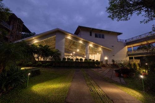 una casa iluminada por la noche con luces en Honeydewwz Exoticaa Hotel & Resort, en Chikmagalur