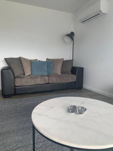 a living room with a couch and a white table at Bay View Bicheno in Bicheno