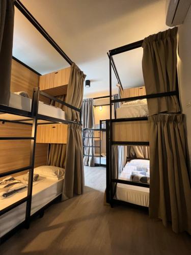 a room with three bunk beds in a hostel at The Freedom Club Hostel KL in Kuala Lumpur