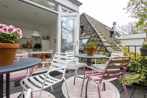 een patio met tafels en stoelen op een balkon bij Achter de Kan in Den Bosch