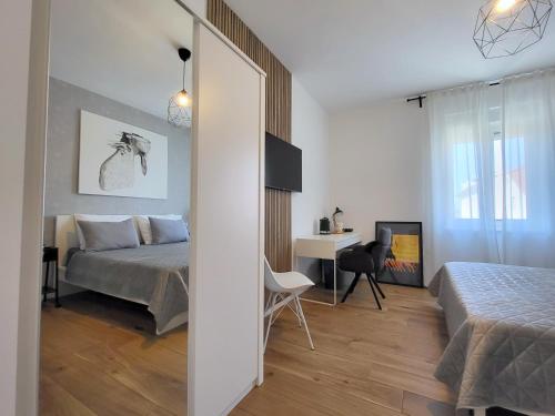 a bedroom with a bed and a desk and a table at Central rooms in Šibenik