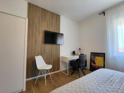 a bedroom with a bed and a desk and a television at Central rooms in Šibenik