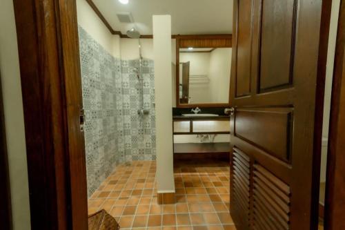 a bathroom with a walk in shower and a sink at Villa Deux Rivieres双河别墅酒店 in Luang Prabang