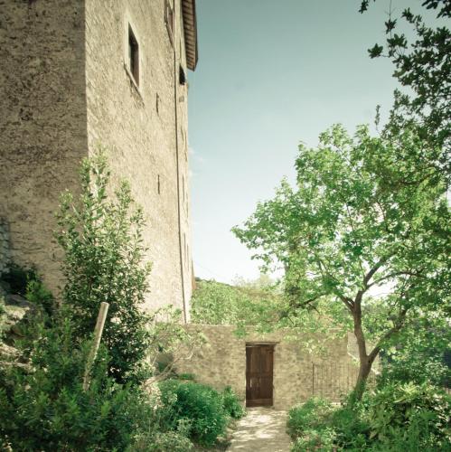 a large brick building with a door and a tree at Borgo San Valentino in Arrone