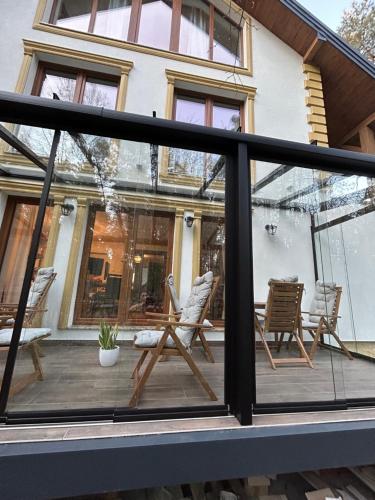a screened in porch with chairs and a table at Leśna Residence & SPA in Pisz