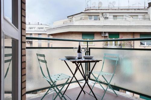 een tafel en stoelen op een balkon met een raam bij Appartamento Trastevere & Pascarella in Rome
