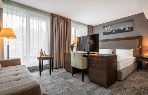 ジビジノにあるHAVET Hotel Resort & Spaのベッドとデスクが備わるホテルルームです。