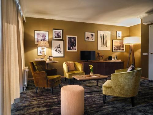 a hotel room with chairs and a tv and a living room at Landgoed De Holtweijde in Lattrop