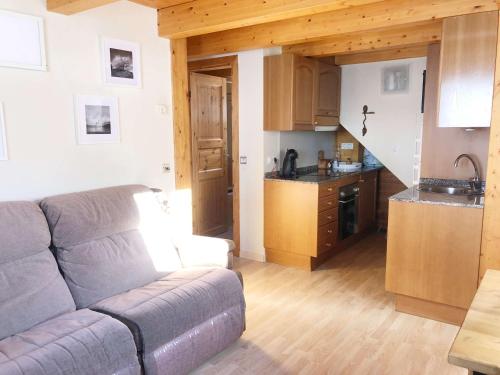 a living room with a couch and a kitchen at Casita de madera a Peu del Riu Incles - Sol y Nieve - Parking incluido in Incles