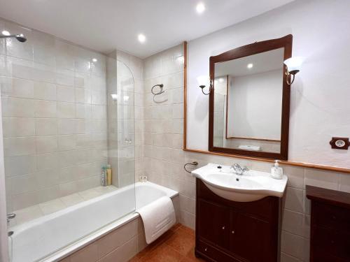La salle de bains est pourvue d'une baignoire, d'un lavabo et d'un miroir. dans l'établissement Apartament La Noguera, à Rialp