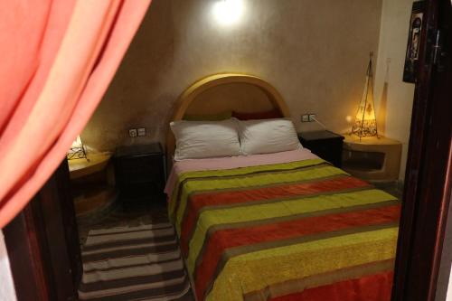 a bedroom with a bed with a multicolored bedspread at Villa Grenadine in Essaouira