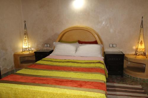 a bedroom with a bed with two night stands and two lamps at Villa Grenadine in Essaouira